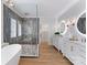 Bright bathroom with a soaking tub, glass shower, marble countertops, and and vanities illuminated by sconces at 6242 Creola Rd, Charlotte, NC 28270