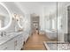 Elegant bathroom featuring double vanities, a freestanding tub, and a glass-enclosed shower with marble tiling at 6242 Creola Rd, Charlotte, NC 28270