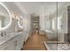 Elegant bathroom featuring dual sinks, a glass shower, and a soaking tub at 6242 Creola Rd, Charlotte, NC 28270
