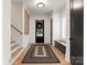 Inviting foyer with hardwood floors, a black front door, built-in bench, and staircase, creating a welcoming entrance at 6242 Creola Rd, Charlotte, NC 28270