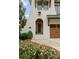 Close up showing the front entrance, beautiful brickwork, arched doorway, and elegant landscaping at 6242 Creola Rd, Charlotte, NC 28270