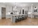 Modern kitchen with white cabinets, stainless steel refrigerator, island seating, and stylish pendant lighting at 6242 Creola Rd, Charlotte, NC 28270