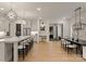 Open-concept kitchen flows into the dining area, featuring modern lighting and views of the front entryway at 6242 Creola Rd, Charlotte, NC 28270