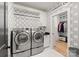 Well-organized laundry room with modern washer and dryer, stylish wallpaper, and ample storage space at 6242 Creola Rd, Charlotte, NC 28270