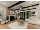 Cozy living room with a fireplace, black ceiling beams and ample natural light, perfect for relaxation and entertaining at 6242 Creola Rd, Charlotte, NC 28270