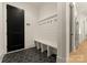 Stylish mudroom with built-in bench, coat hooks, and decorative black and white tile flooring at 6242 Creola Rd, Charlotte, NC 28270