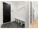 Chic mudroom featuring black hexagon tile flooring, built-in bench with coat hooks, and adjacent doorway at 6242 Creola Rd, Charlotte, NC 28270