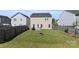 Fenced backyard with green grass, fire pit, and patio area, perfect for outdoor gatherings and relaxation at 6945 Agava Ln, Charlotte, NC 28215