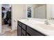 Bright bathroom with a double sink vanity, neutral walls, and closet access at 6945 Agava Ln, Charlotte, NC 28215