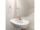 Modern bathroom with a pedestal sink, mirror, and neutral walls at 6945 Agava Ln, Charlotte, NC 28215