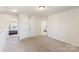 Bright bedroom with neutral carpet, closet, and doorways leading to additional rooms and a view of the second bedroom at 6945 Agava Ln, Charlotte, NC 28215