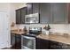 Modern kitchen featuring granite countertops, stainless steel appliances, and dark cabinetry at 6945 Agava Ln, Charlotte, NC 28215