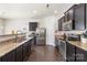 Well-lit kitchen with granite countertops, dark cabinets, stainless steel appliances, and dark hardwood floors at 6945 Agava Ln, Charlotte, NC 28215