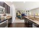 Stylish kitchen features granite counters, stainless appliances, dark cabinets, and is open to the living area at 6945 Agava Ln, Charlotte, NC 28215