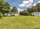 Expansive backyard with lush green grass, mature trees, a storage shed, and a white home at 703 Bradberry Ln, Indian Trail, NC 28079
