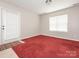 Bedroom with red carpet, a window, and an exterior door at 703 Bradberry Ln, Indian Trail, NC 28079
