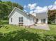 Exterior view of a white home with brick patio, siding, and large windows overlooking the landscaped yard at 703 Bradberry Ln, Indian Trail, NC 28079