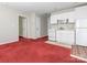 Kitchenette with white appliances and cabinets, red carpet at 703 Bradberry Ln, Indian Trail, NC 28079