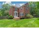 Brick home with a spacious backyard featuring a well-maintained lawn and wooden deck at 7301 Leharne Dr, Charlotte, NC 28270