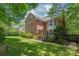 Two story brick home showing a manicured backyard, deck, and mature landscaping at 7301 Leharne Dr, Charlotte, NC 28270