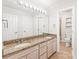 Double vanity bathroom featuring a granite countertop, decorative mirror, and convenient storage options at 7301 Leharne Dr, Charlotte, NC 28270