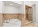 Luxurious bathroom features a soaking tub and glass-enclosed shower with modern fixtures and stone tile at 7301 Leharne Dr, Charlotte, NC 28270