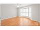 Bright bedroom with hardwood floors, ceiling fan, and bay window with white shutters at 7301 Leharne Dr, Charlotte, NC 28270