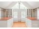 Spacious walk-in closet boasts custom built-ins, ample storage, and natural light from large windows at 7301 Leharne Dr, Charlotte, NC 28270