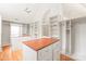 Elegant walk-in closet with custom shelving, a center island, and a chandelier fixture at 7301 Leharne Dr, Charlotte, NC 28270