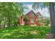 Exterior view of a two-story brick home featuring a well-manicured front lawn at 7301 Leharne Dr, Charlotte, NC 28270