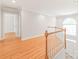 Hallway featuring hardwood floors with white trim and access to the upper floor at 7301 Leharne Dr, Charlotte, NC 28270