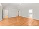 Open-concept living room featuring hardwood floors and access to multiple rooms of the home at 7301 Leharne Dr, Charlotte, NC 28270