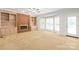 Spacious living room featuring a brick fireplace, built-in shelving, and large windows, offering a cozy and inviting atmosphere at 7301 Leharne Dr, Charlotte, NC 28270