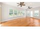 Sunlit living room with hardwood floors, multiple windows, and ceiling fans showcases a comfortable living space at 7301 Leharne Dr, Charlotte, NC 28270
