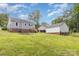 An ample backyard with a fire pit, leading to a house with wooden steps and a detached garage at 810 Maplewood Ave, Kannapolis, NC 28081