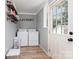 Functional laundry room with washer, dryer, and storage shelves at 810 Maplewood Ave, Kannapolis, NC 28081