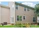 Back of the house featuring neutral siding, multiple windows, and a garden, blending with nature at 8618 Sam Dee Rd, Charlotte, NC 28215