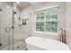 Modern bathroom featuring a glass shower, soaking tub and a view at 8618 Sam Dee Rd, Charlotte, NC 28215