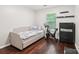 Bedroom with hardwood floors, daybed, exercise bike, dresser, and natural light from the window at 8618 Sam Dee Rd, Charlotte, NC 28215