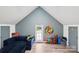Comfortable bonus room with a blue sofa, creative dart board, and toys at 8618 Sam Dee Rd, Charlotte, NC 28215