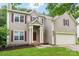 Inviting two-story home with light brown siding, red shutters, and covered front entrance with white pillars at 8618 Sam Dee Rd, Charlotte, NC 28215