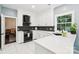 Well-lit kitchen with white cabinets, stainless steel appliances, and a black backsplash at 8618 Sam Dee Rd, Charlotte, NC 28215