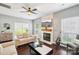 Comfortable living room with a stone fireplace, ceiling fan, and bright windows at 8618 Sam Dee Rd, Charlotte, NC 28215