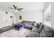Cozy living room with a plush gray sectional, ceiling fan, and ample natural light at 8618 Sam Dee Rd, Charlotte, NC 28215