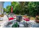 Charming backyard patio with a cozy fire pit and seating, surrounded by lush greenery and privacy at 8909 Savannah Rd, Harrisburg, NC 28075