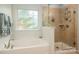 Bright bathroom with soaking tub, a glass shower, and large window for natural light at 8909 Savannah Rd, Harrisburg, NC 28075