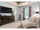 A well-appointed bedroom shows a flat-screen television and an extra chair for relaxing at 8909 Savannah Rd, Harrisburg, NC 28075
