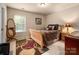 Bedroom features a bed, dresser, large windows, and decorative furnishings at 8909 Savannah Rd, Harrisburg, NC 28075