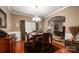 Cozy dining area featuring a classic chandelier, rich hardwood floors, and a view into the living room at 8909 Savannah Rd, Harrisburg, NC 28075