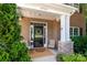 Inviting front porch with a wreath, cozy seating, and brick and stone accents at 8909 Savannah Rd, Harrisburg, NC 28075